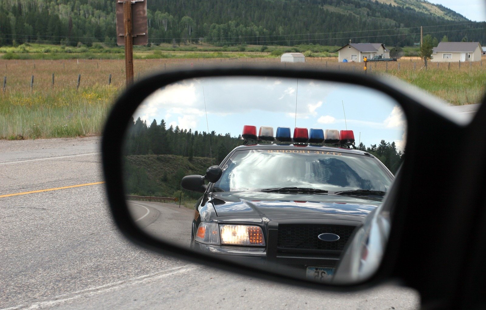 Police vehicle viewed in a rear-view mirror